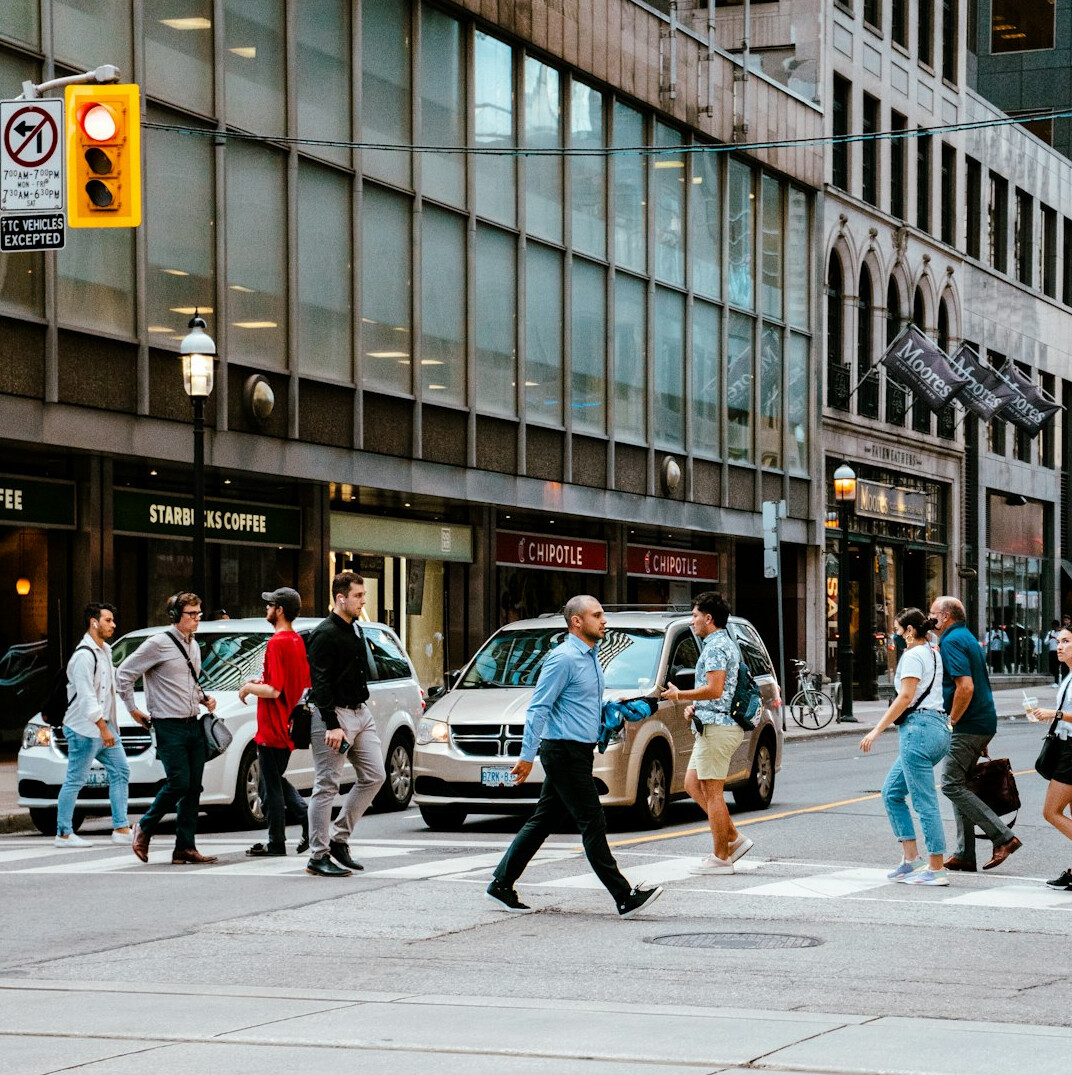 Crowd of pedestrians crossing a busy downtown Toronto intersection