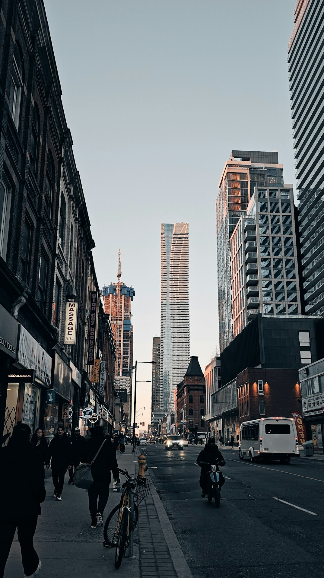 Wide view of a Canadian city skyline street with pedestrians and cyclists