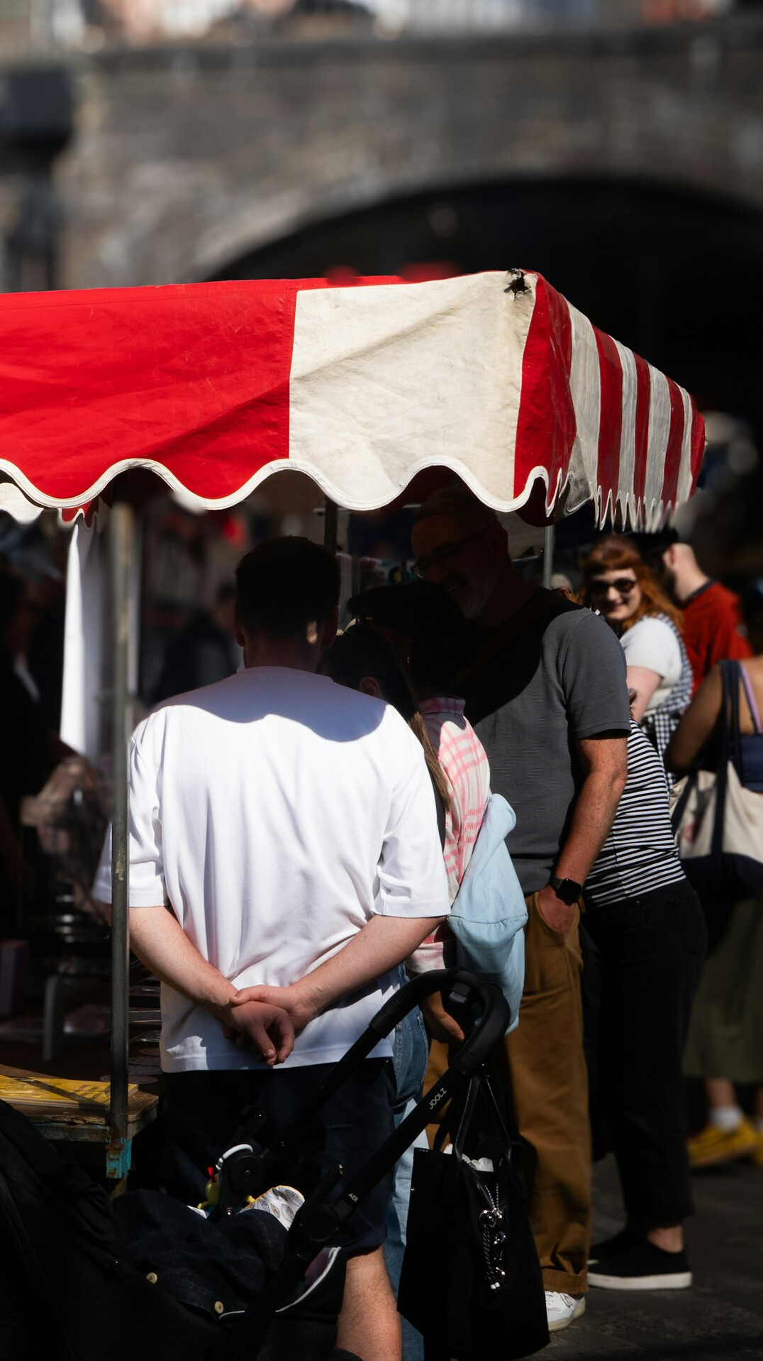 People waiting in line at an outdoor market stall